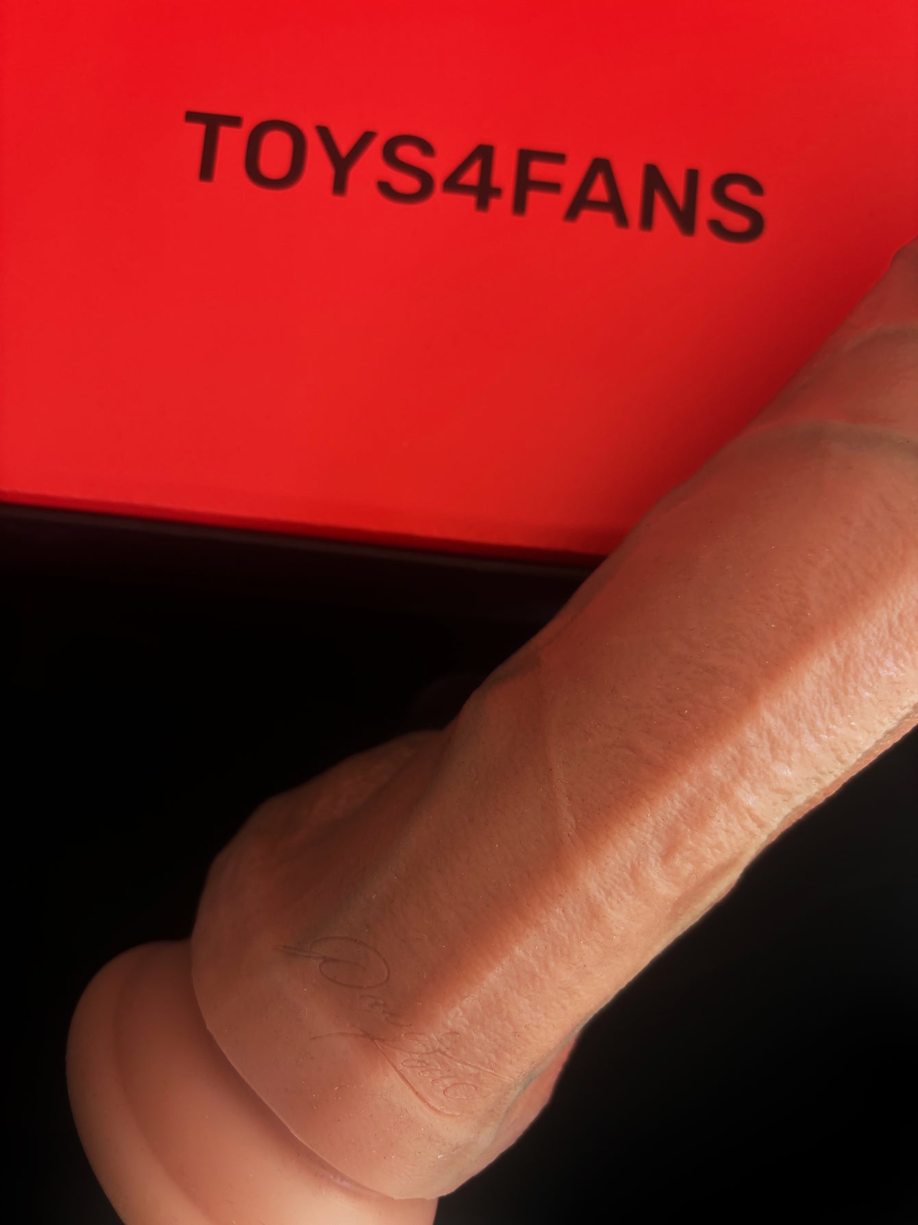 The Papi Kocic Dildo by TOYS4FANS is shown against a red background, with the brand name displayed in bold black letters.